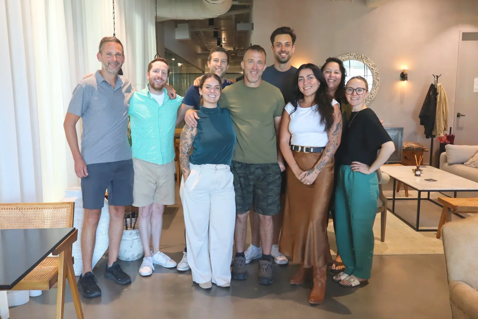 The Scribe team, ten people standing together in an office